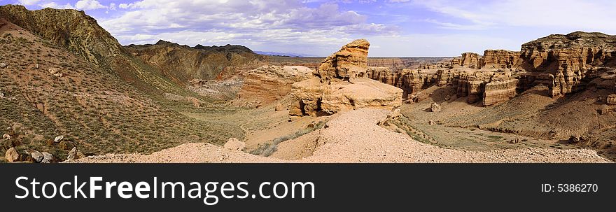 Panorama of lonely rock on cloudy sky