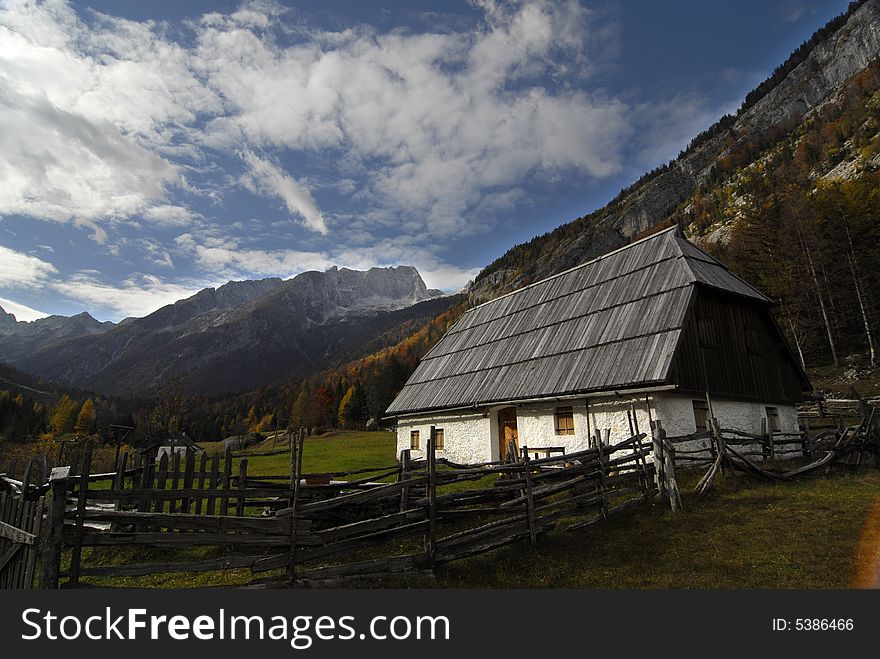 Small traditional alpine house in the valley surrounded by the Julian alps. Small traditional alpine house in the valley surrounded by the Julian alps