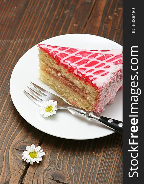 A slice of a cream cake and flowers.