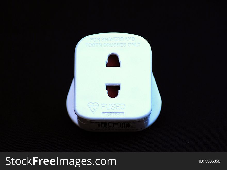 Shot of a white adapter plug aganst a black background. Shot of a white adapter plug aganst a black background