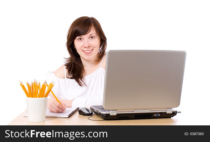Young female office worker, laptop, pencils, notebook on desk, isolated. Young female office worker, laptop, pencils, notebook on desk, isolated