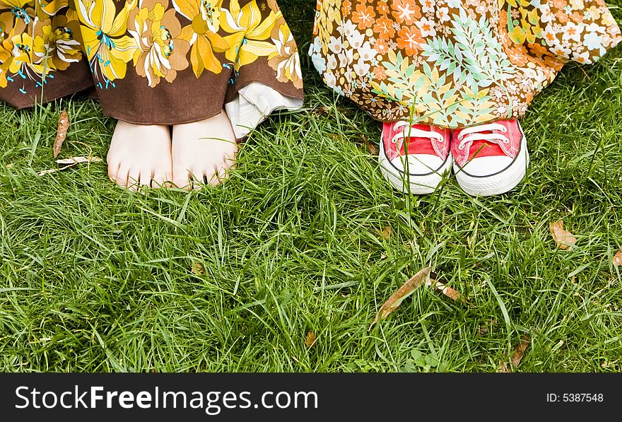 Woman feets under dress over the grass. Woman feets under dress over the grass