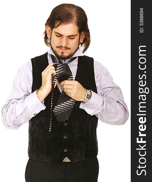 Young man wearing vest, getting ready to party and finishing his tie. Young man wearing vest, getting ready to party and finishing his tie