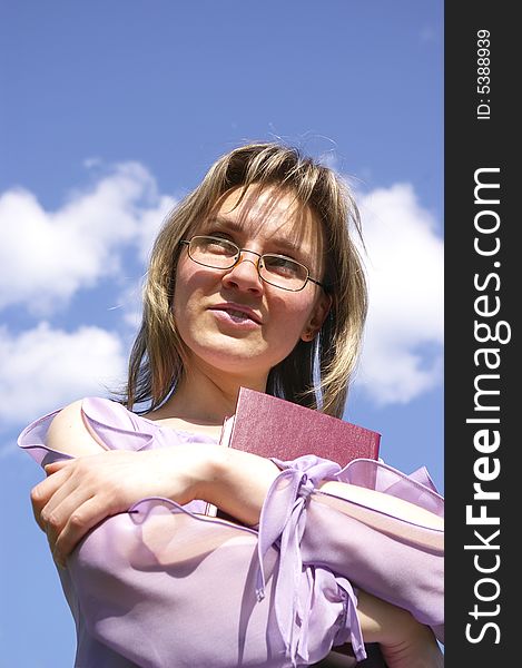 Smiling woman in lilac holding a book