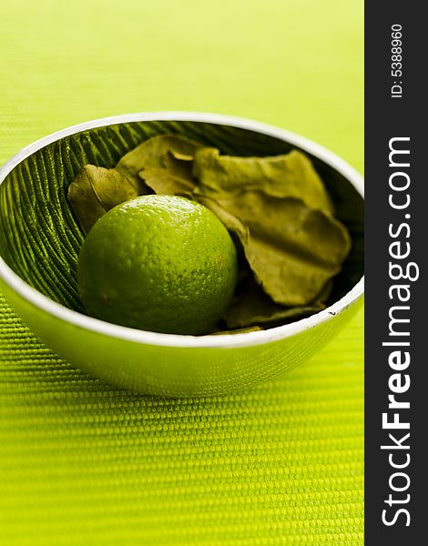 Lime with kafir leaves on the green table