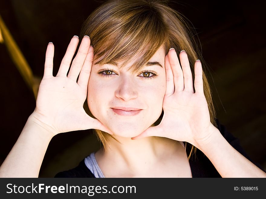 Beautiful blond woman framing herself with her hands. Beautiful blond woman framing herself with her hands