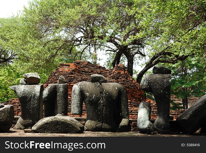 In Thailand the city of Ayutthaya was founded in 1350 today is an impressive archaeological park; here a view of the Wat Ratburana or Ratchaburana ruins built in 1424 with an ancient statue of Buddha. In Thailand the city of Ayutthaya was founded in 1350 today is an impressive archaeological park; here a view of the Wat Ratburana or Ratchaburana ruins built in 1424 with an ancient statue of Buddha