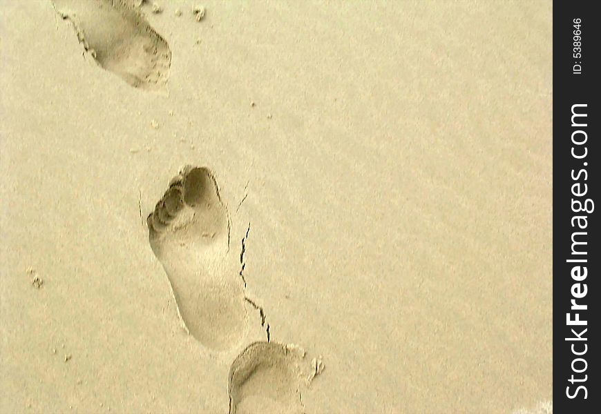 A human footprint in the sand on beach. A human footprint in the sand on beach.