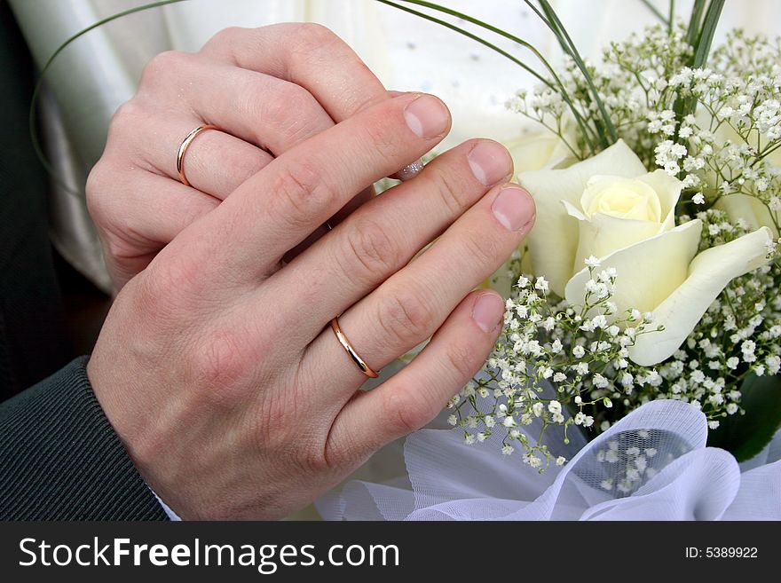 Two rings on fingers newly married, a bouquet of yellow roses in a hand. Two rings on fingers newly married, a bouquet of yellow roses in a hand