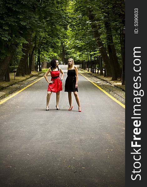 Two young models parading under green forest. Two young models parading under green forest