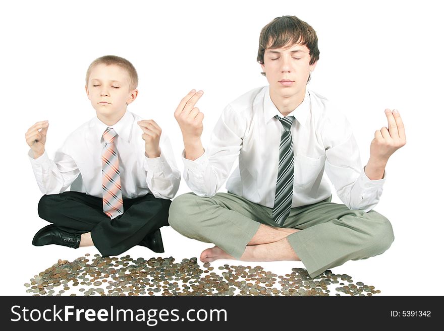 Two boys meditate sitting near money. Two boys meditate sitting near money.