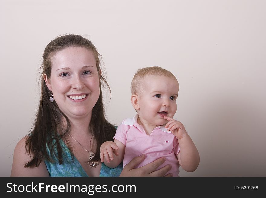 A young woman with her baby daughter looking away. A young woman with her baby daughter looking away