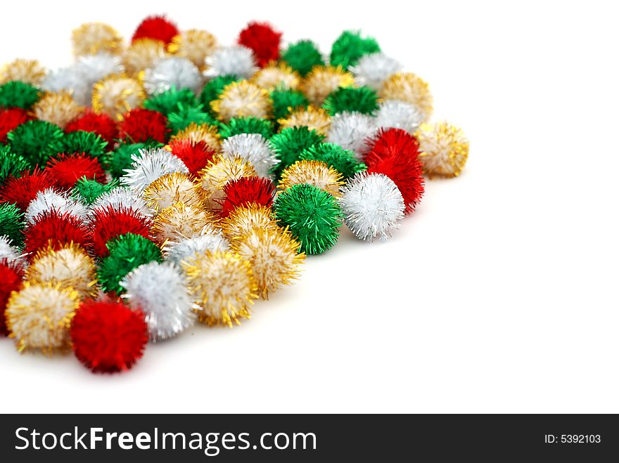 Pile of small sparkling festive deocation puff-balls on a white background. Pile of small sparkling festive deocation puff-balls on a white background