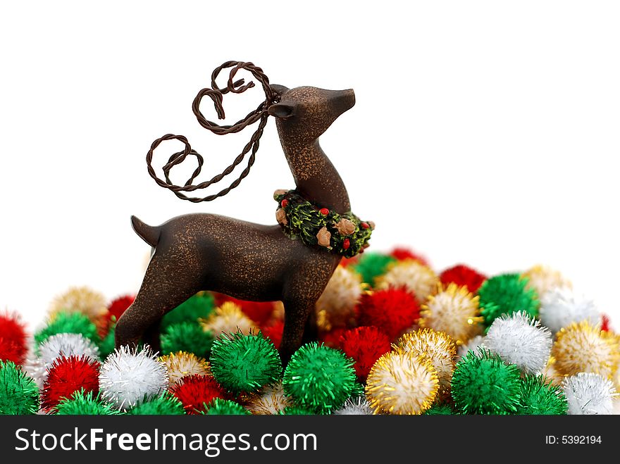 Reindeer ornament and colorful puff ball decorations over a white background. Reindeer ornament and colorful puff ball decorations over a white background