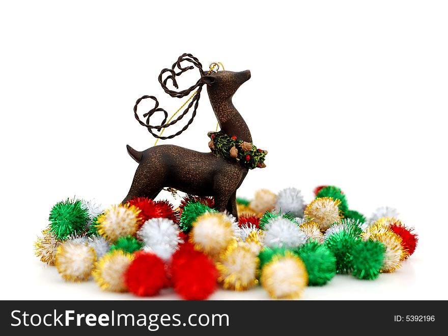 Reindeer ornament and colorful puff ball decorations over a white background. Reindeer ornament and colorful puff ball decorations over a white background