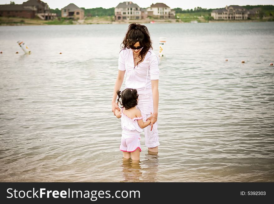 Mother and daughter holding hands at the beach