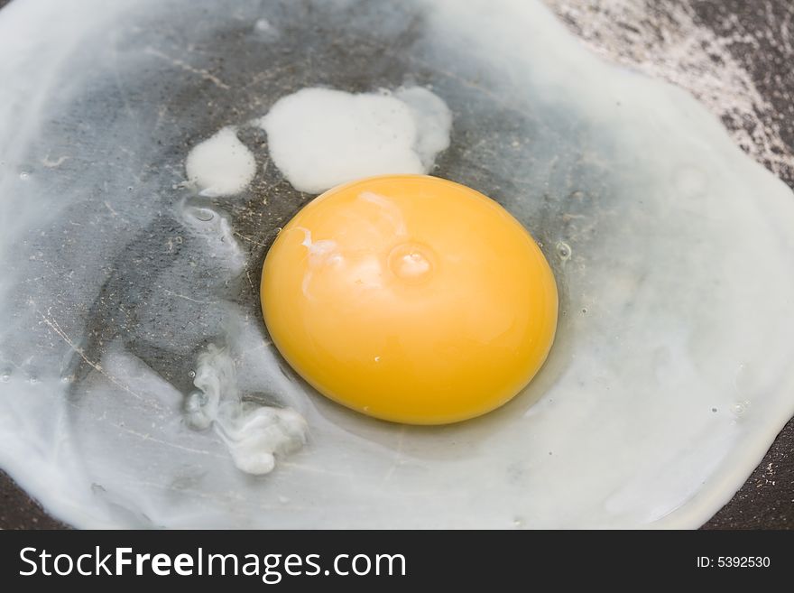 Frying the egg in griddle close-up