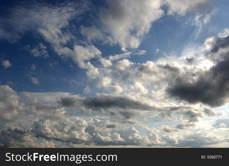 Puffy white clouds hang in a bright blue sky. Puffy white clouds hang in a bright blue sky.