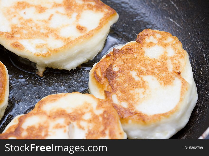 Cooking fresh cheese cakes in the frying pan. Cooking fresh cheese cakes in the frying pan
