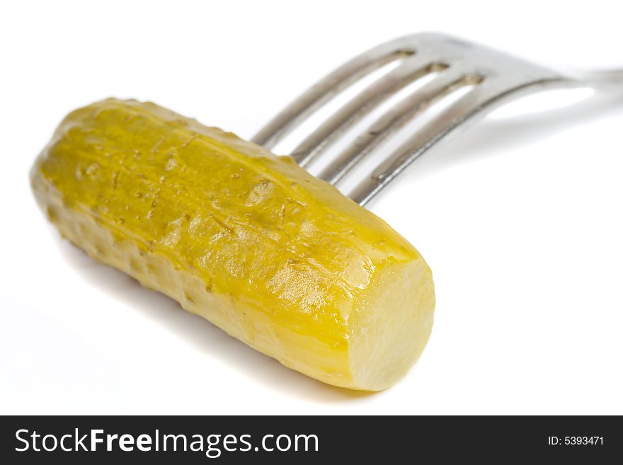 Close-up pickled cucumber on fork, isolated on white