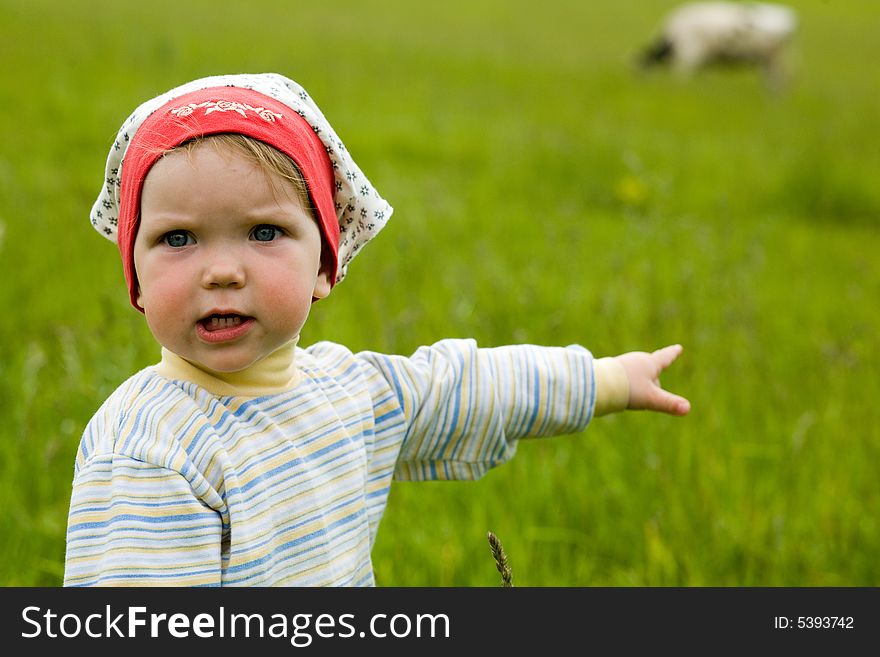 An image of a baby in green field. An image of a baby in green field