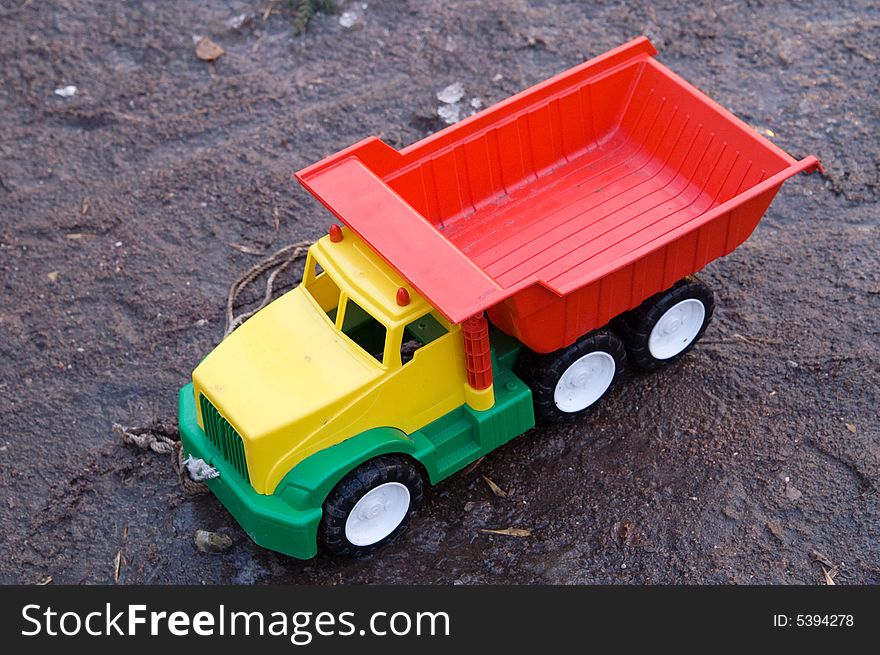 Baby toy dump truck in dirt (transportation)