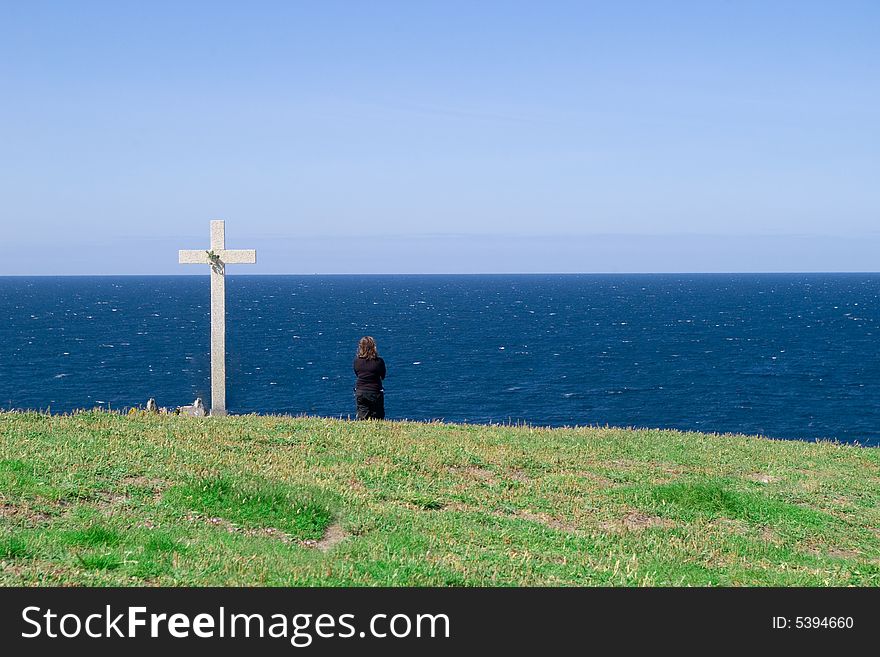 Widow in black watching the sea beside death triburte