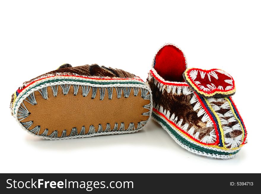 Baby's (childs) embroidered mocassins with leather sole on overwhite background. Baby's (childs) embroidered mocassins with leather sole on overwhite background.