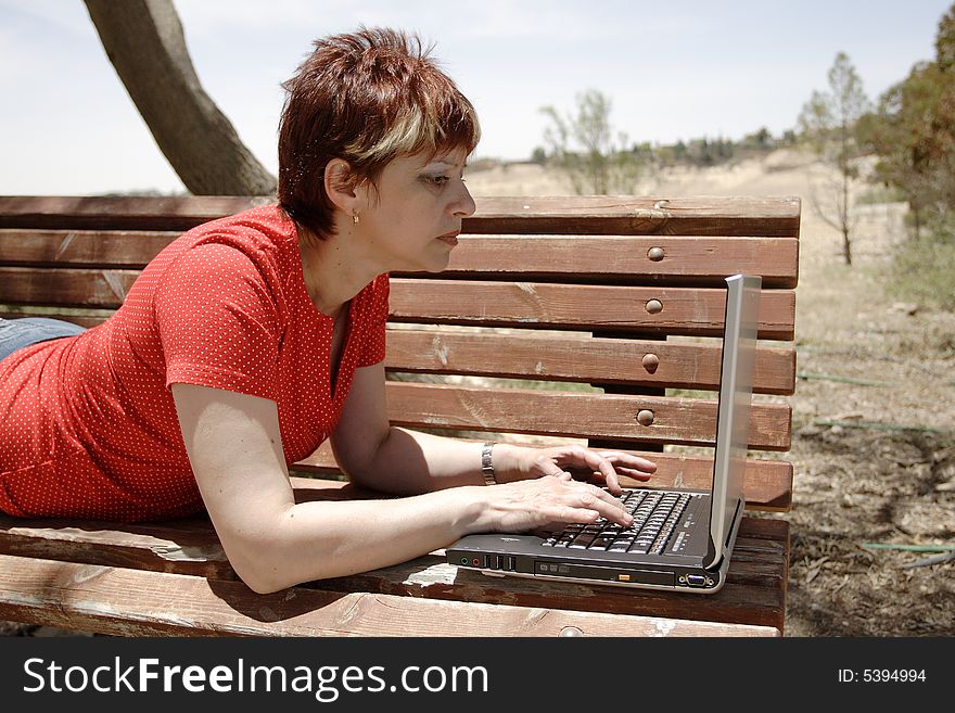 A young woman using a portable computer outside. A young woman using a portable computer outside