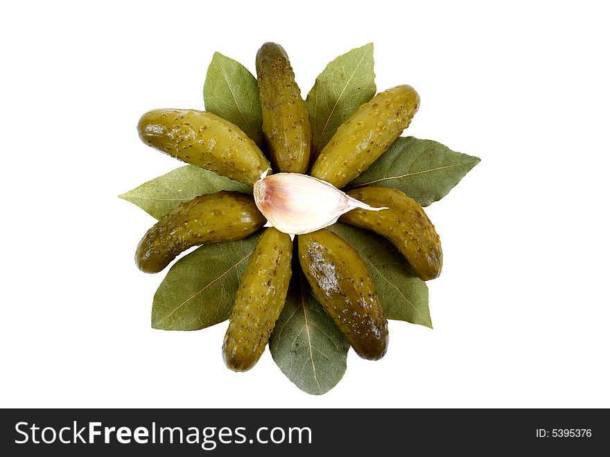 Gherkins lies on laurel with garlic isolated on white background. Gherkins lies on laurel with garlic isolated on white background