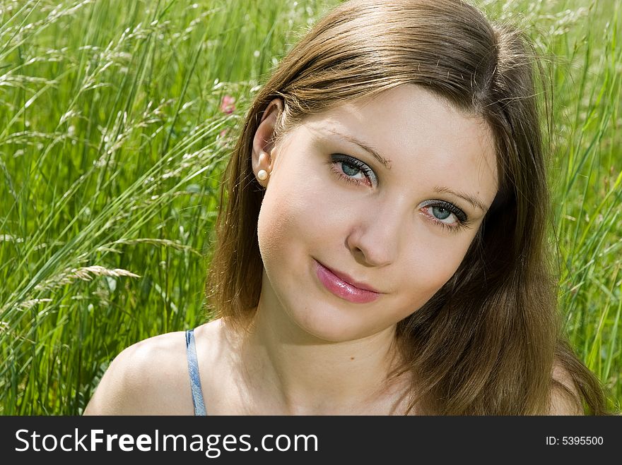 Close up of young romantic girl sitting in tall grass