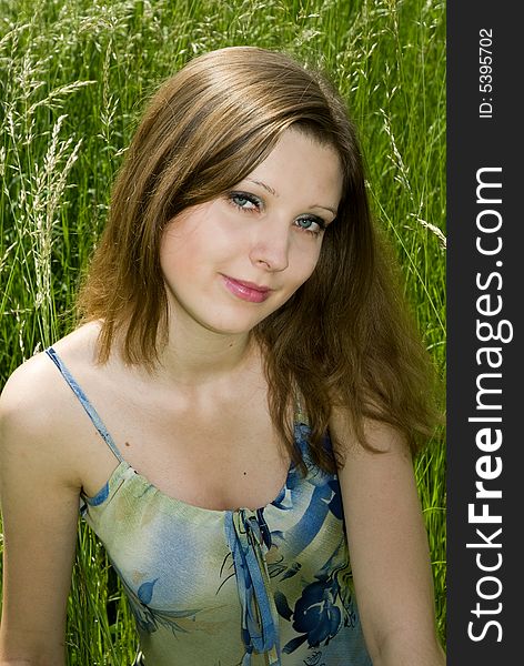 Young romantic girl sitting in tall grass