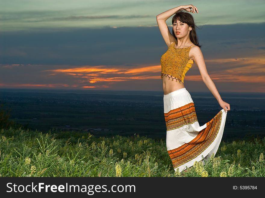 Young beautiful asian woman dancing at sunset, note there is some motion blur. Young beautiful asian woman dancing at sunset, note there is some motion blur