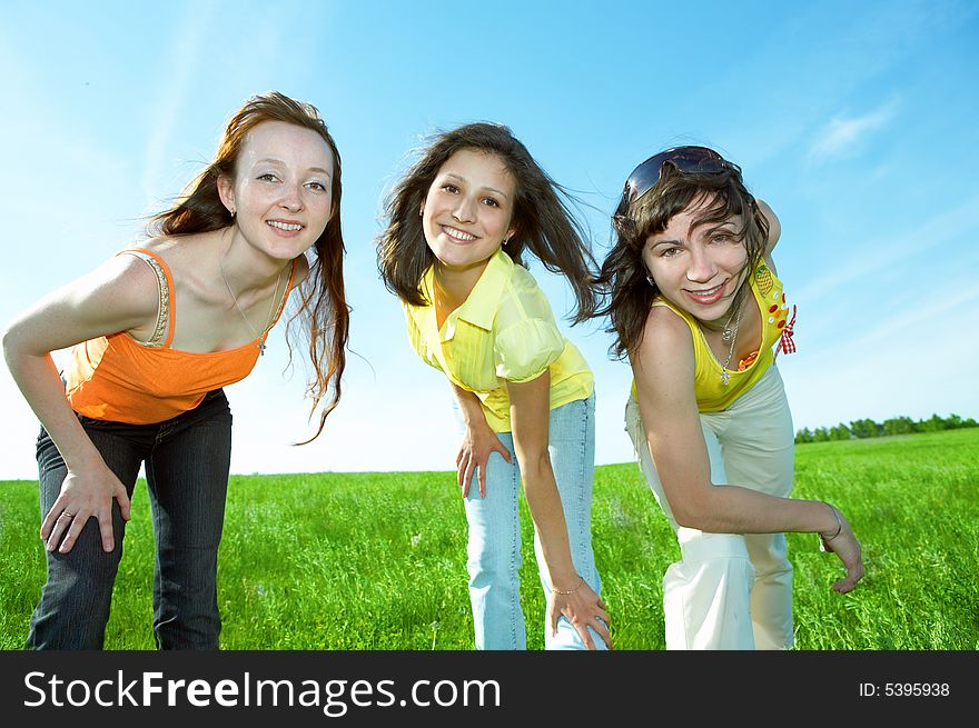 Three friend have fun in green field under blue sky