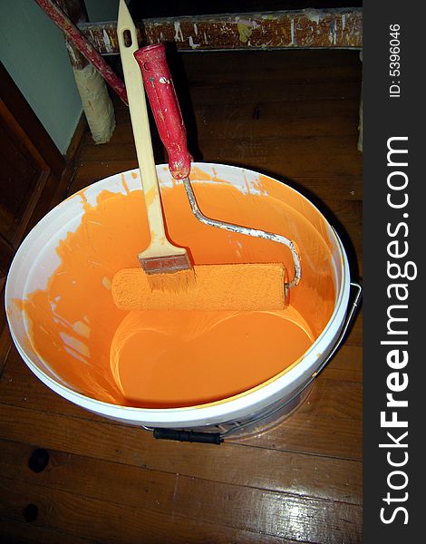 Paint bucket - orange color - roller and brush. Paint bucket - orange color - roller and brush