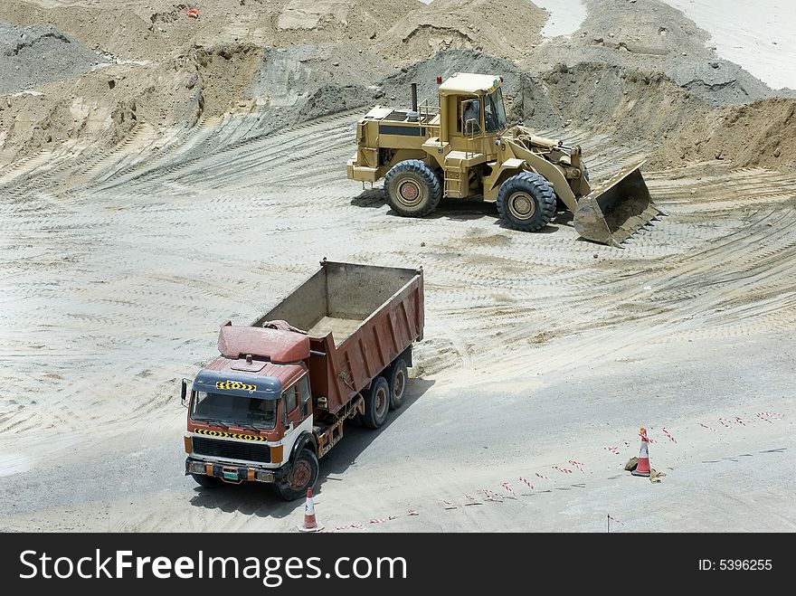 Two construction machineries clearing the sand. Two construction machineries clearing the sand
