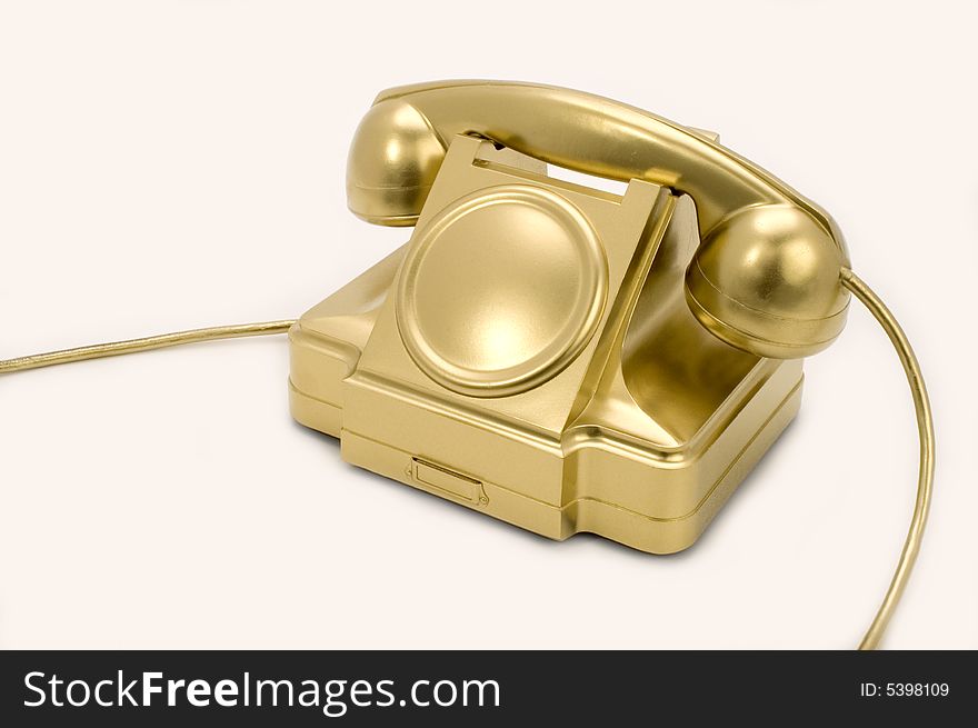 The telephone of gold colour on a white background. The telephone of gold colour on a white background.