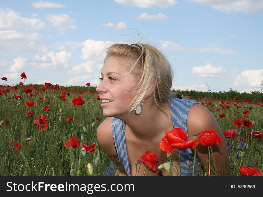 Young woman relaxing. sun weather and poppy field. Young woman relaxing. sun weather and poppy field