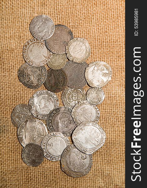 A lot of old silver coins with portraits of kings on the old cloth. A lot of old silver coins with portraits of kings on the old cloth