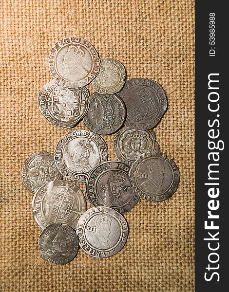 A lot of old silver coins with portraits of kings on the old cloth. A lot of old silver coins with portraits of kings on the old cloth