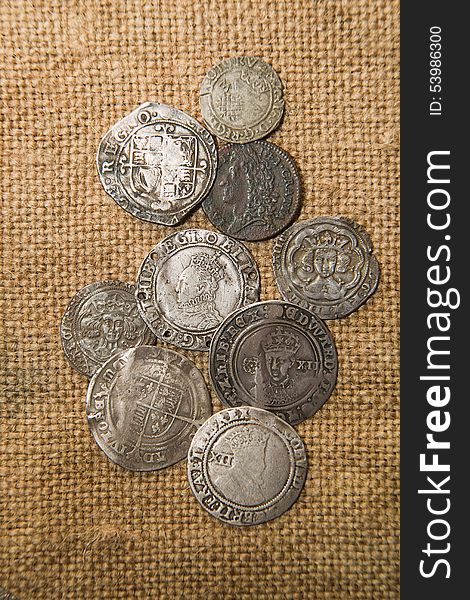 A lot of old silver coins with portraits of kings on the old cloth. A lot of old silver coins with portraits of kings on the old cloth