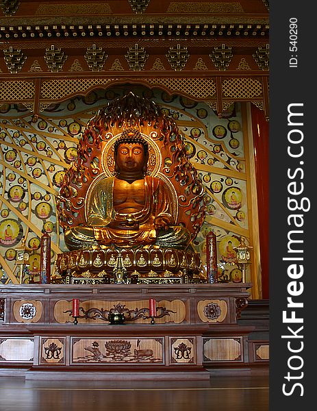 Golden Buddha in Buddhist temple with wooden floor