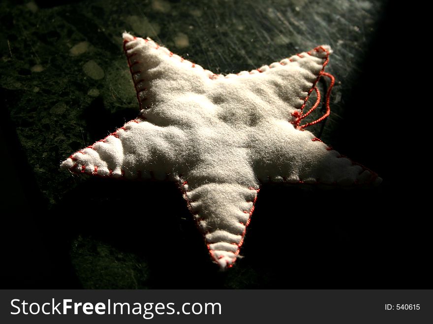 Handmade star-shaped Christmas ornament on black background. Handmade star-shaped Christmas ornament on black background