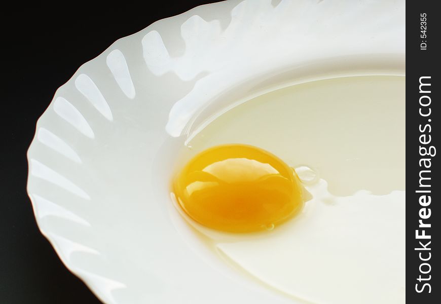 Still life with egg on white dish and black background. Still life with egg on white dish and black background
