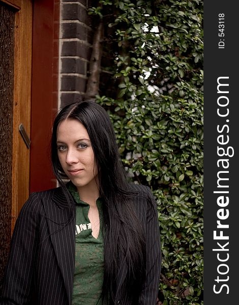 Beautiful Girl in casual business suit in front of a house. Beautiful Girl in casual business suit in front of a house