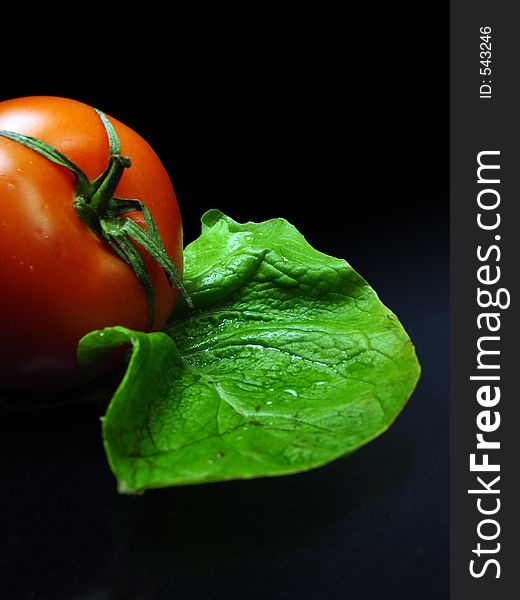 Tomato and salat on black background