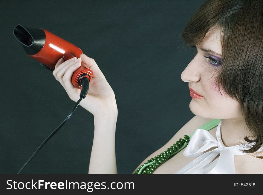 Young woman with hairdryer, profile. Young woman with hairdryer, profile