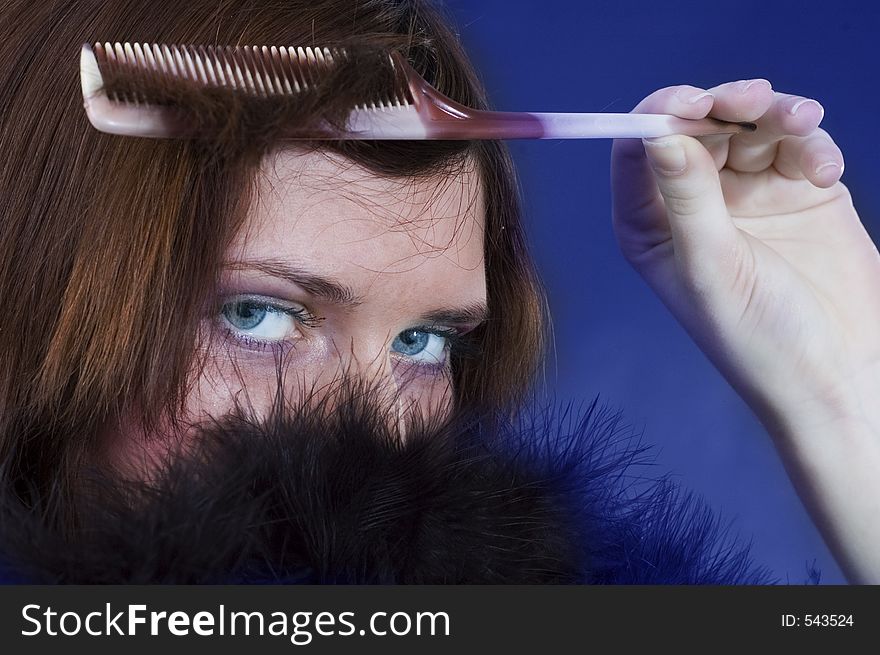 Young girl with a hairbrush and black feathers. Young girl with a hairbrush and black feathers