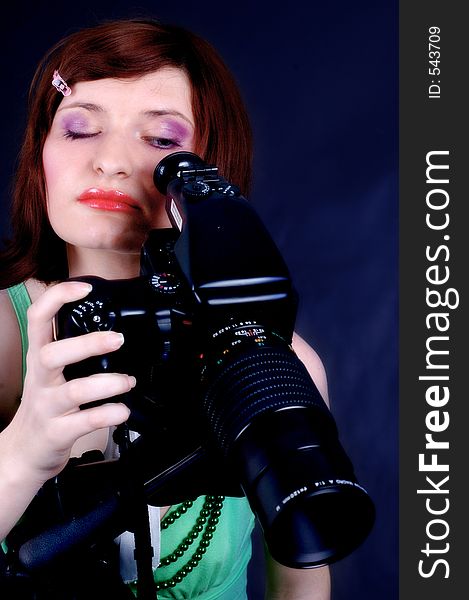 Young woman with great make-up playing with a studio camera. Young woman with great make-up playing with a studio camera