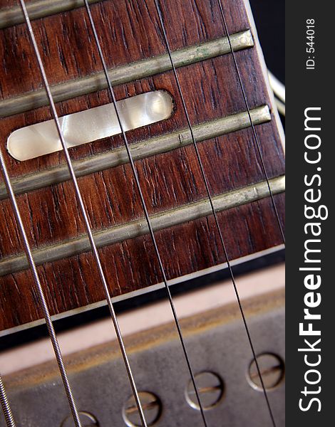 Close up of the fret board and pick up of an old guitar, conceptual quality. Close up of the fret board and pick up of an old guitar, conceptual quality